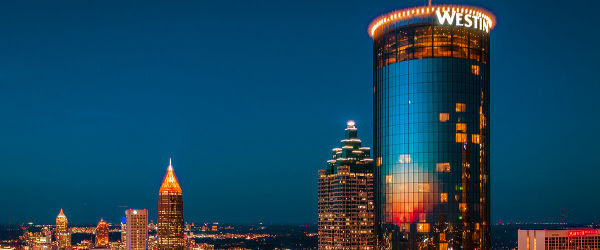 The Westin Peachtree Plaza tower lit at dusk above the Atlanta skyline